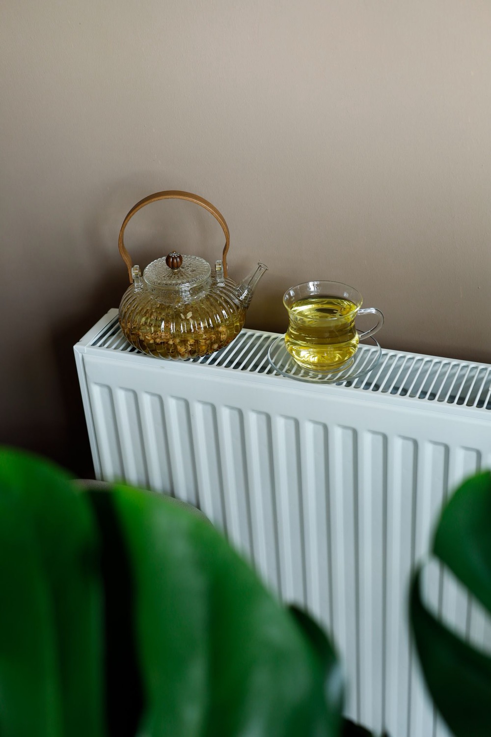 Théière et tasse de thé posées sur un radiateur blanc